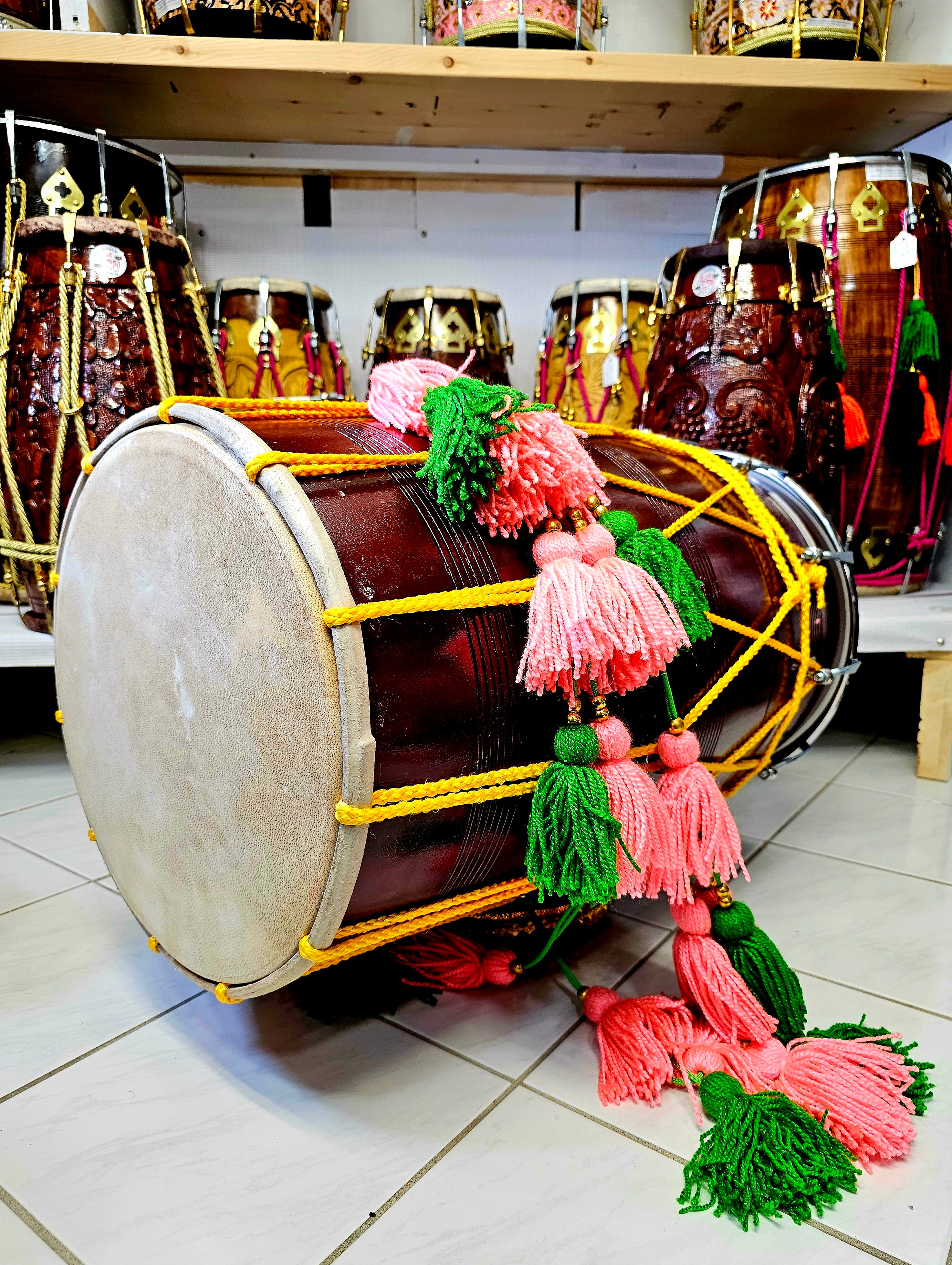 The Burgundy Fiesta Melody Dhol - A Professional Mango Wood Dhol with Yellow Ropes, Chrome Bolts, and Pink and Green Tassels!