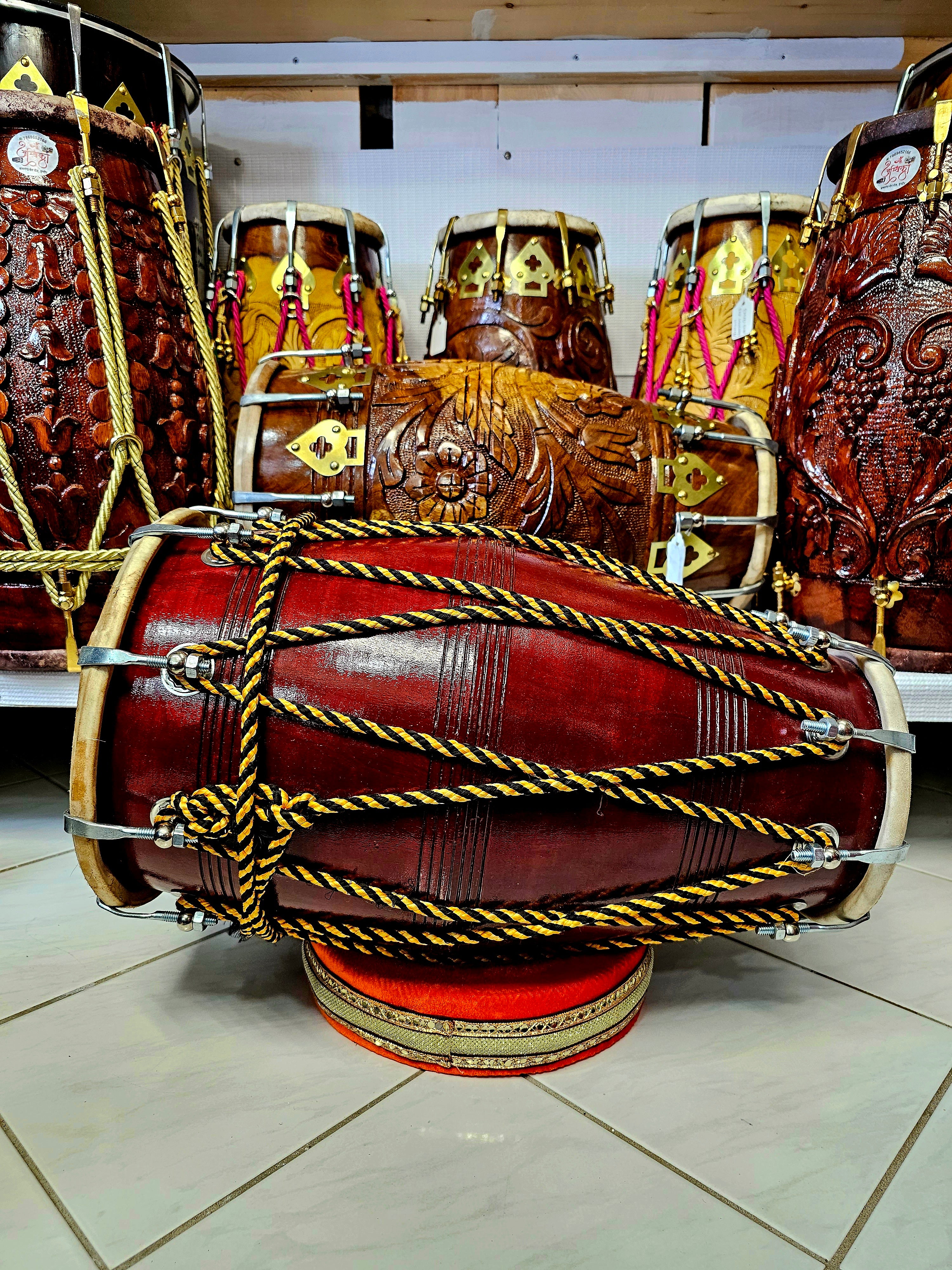 The HoneyComb Harmony Dholak - A Burgundy Professional Mango Wood Dholak with Yellow and Black Ropes, Chrome Bolts, and a Handle!