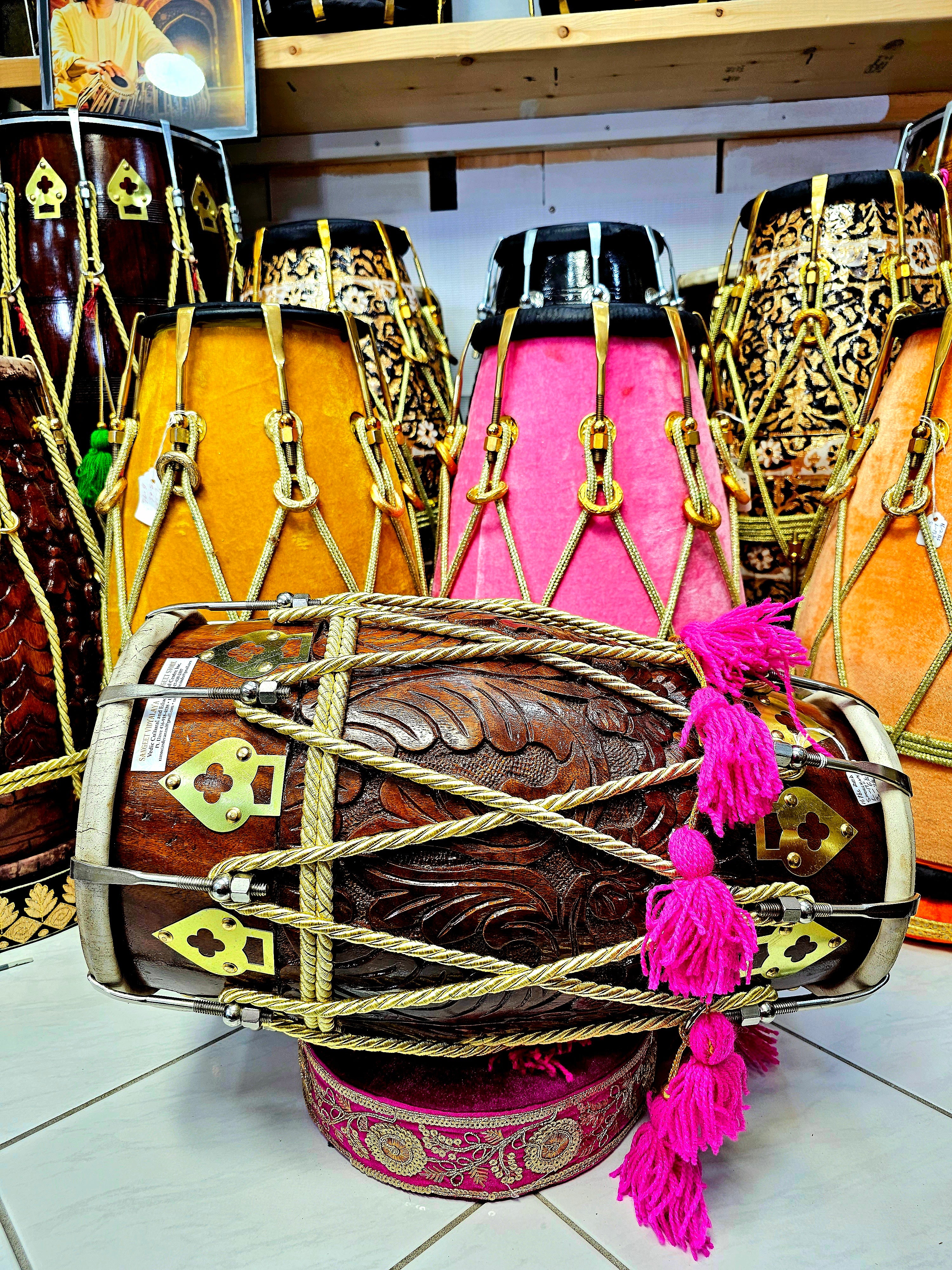 Melodic Opulence: Encarved Red Sheesham Dholak with Golden Ropes Design, Pink Tassels, and Chrome Bolts (BLACK FRIDAY SALE!)