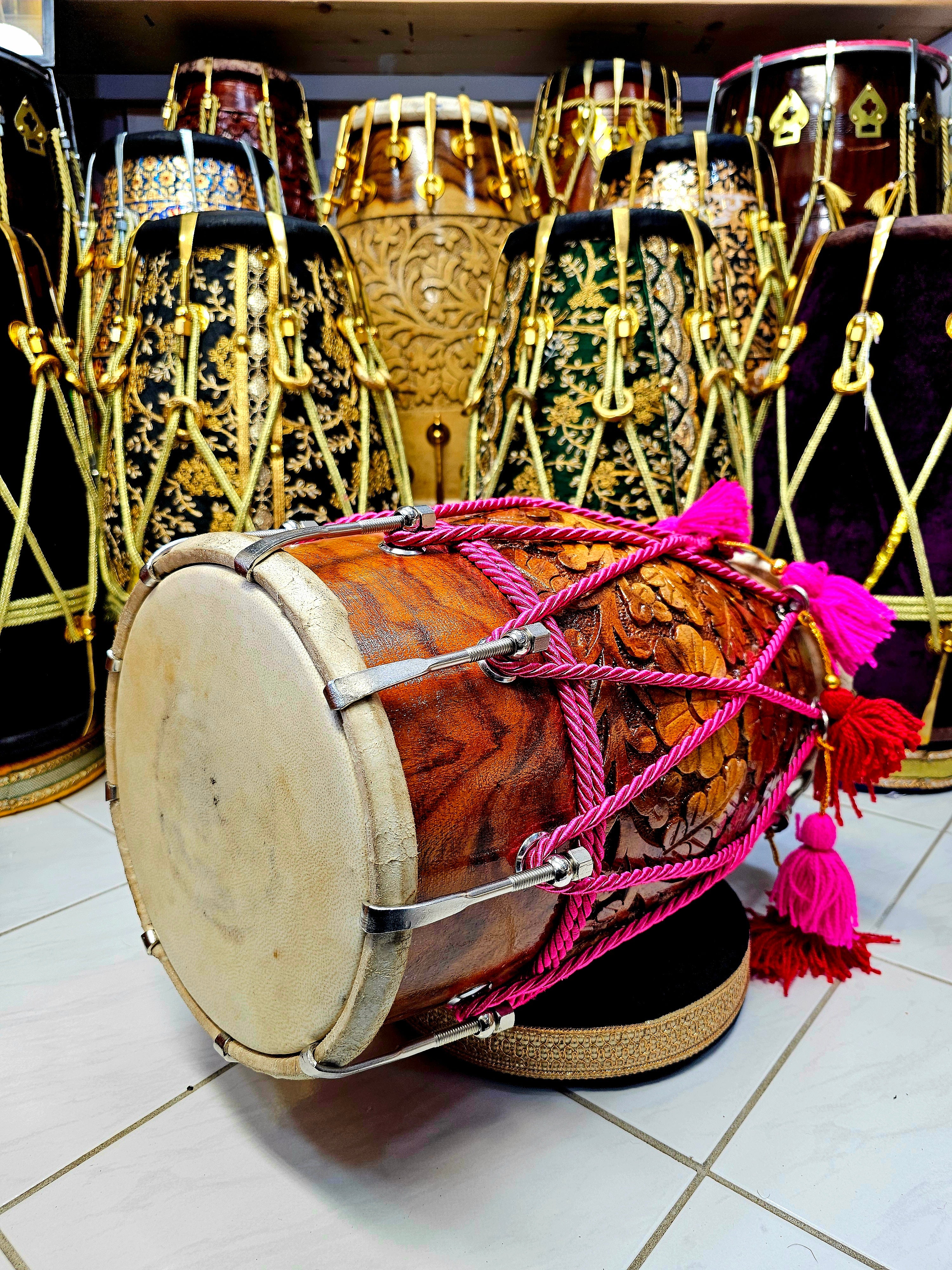 Blossoming Beats: Floral Encarved Red Sheesham Dholak with Chrome Bolts, Pink Ropes Design, and Vibrant Tassels