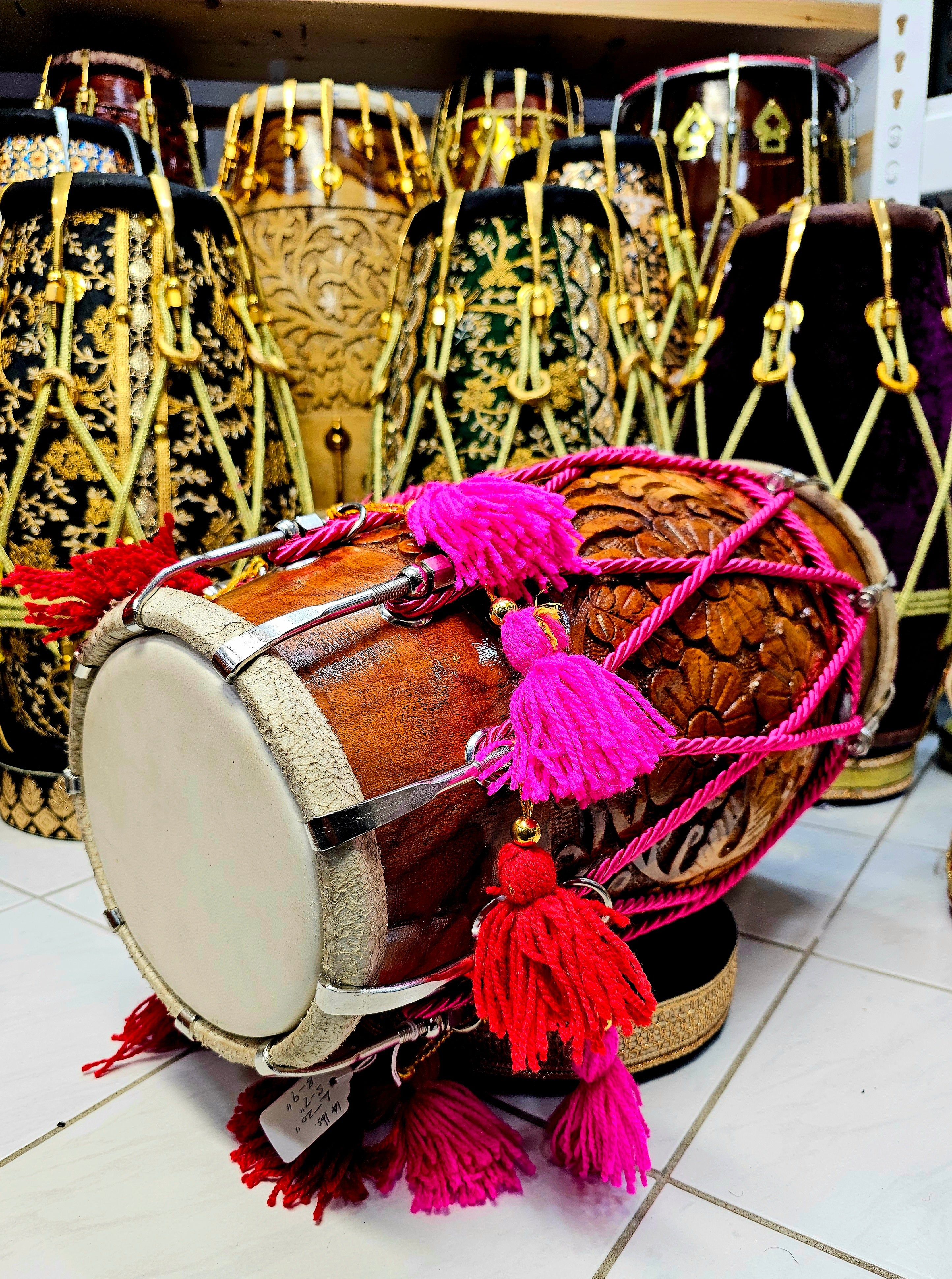 Blossoming Beats: Floral Encarved Red Sheesham Dholak with Chrome Bolts, Pink Ropes Design, and Vibrant Tassels