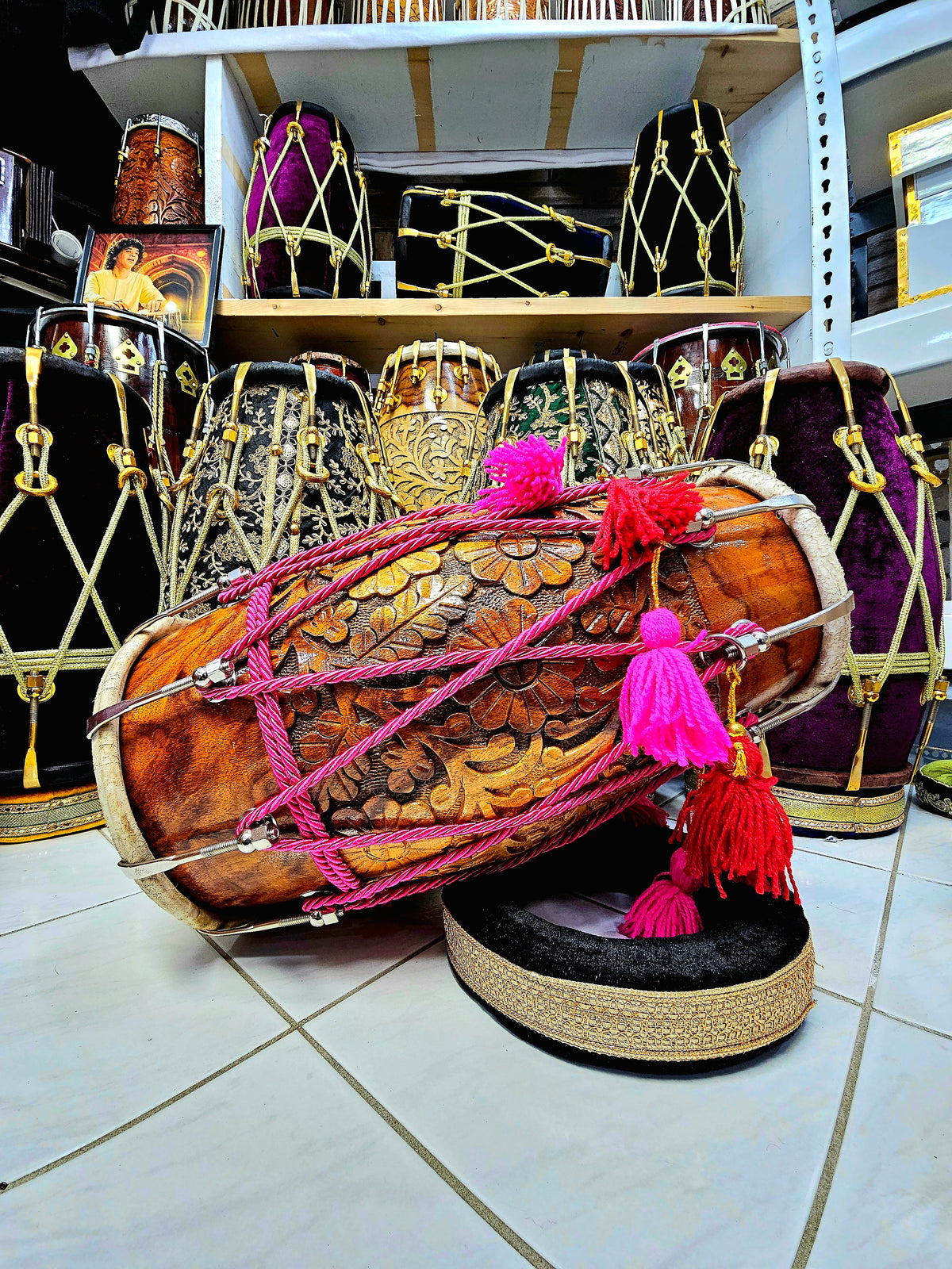 Blossoming Beats: Chetram Gill's Floral Encarved Red Sheesham Dholak with Chrome Bolts, Pink Ropes Design, and Vibrant Tassels