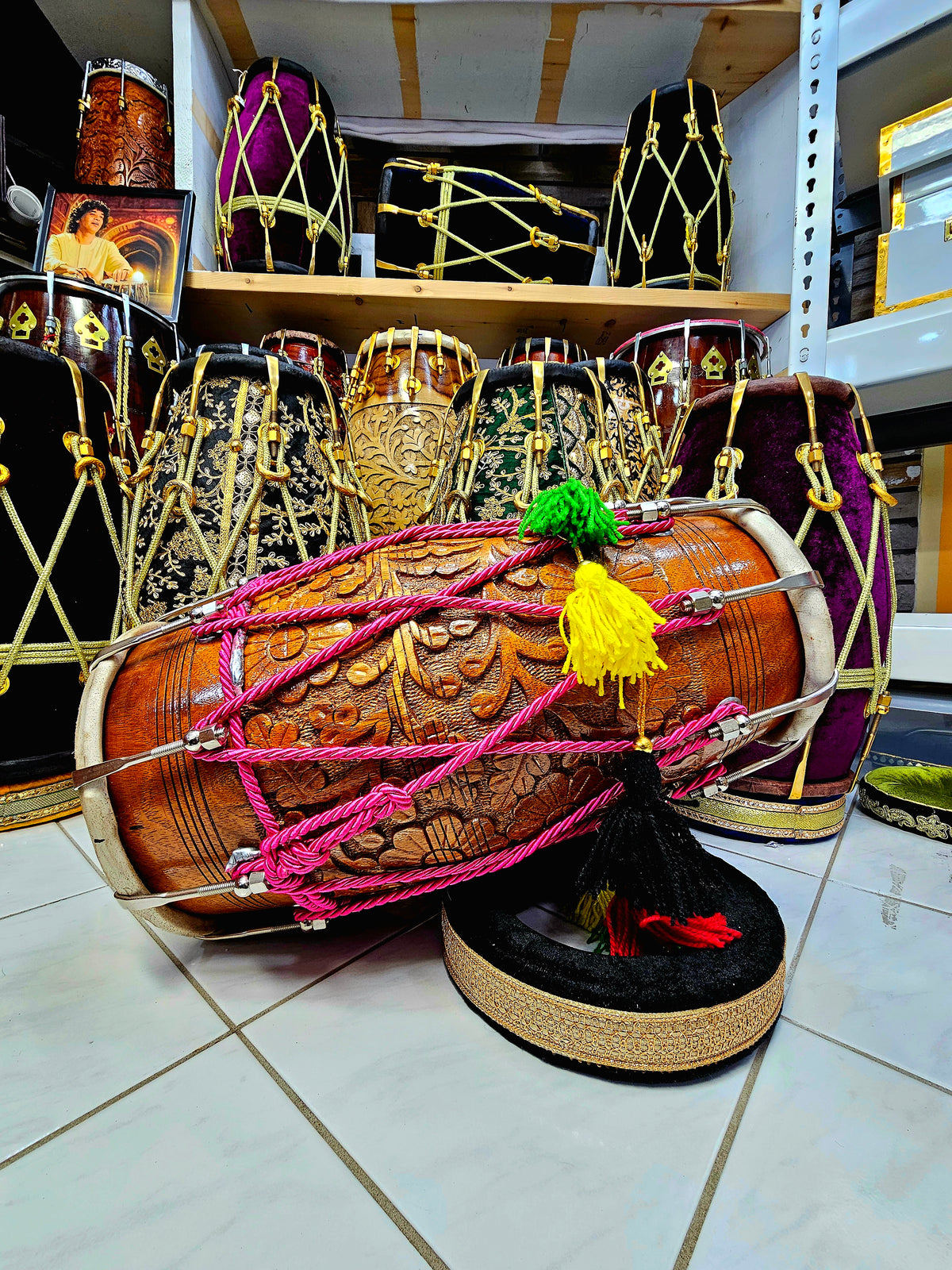 Blossom Melodies: Chetram Gill's Floral Encarved Red Sheesham Dholak with Chrome Bolts, Pink Roped Design, and Multicolored Tassels