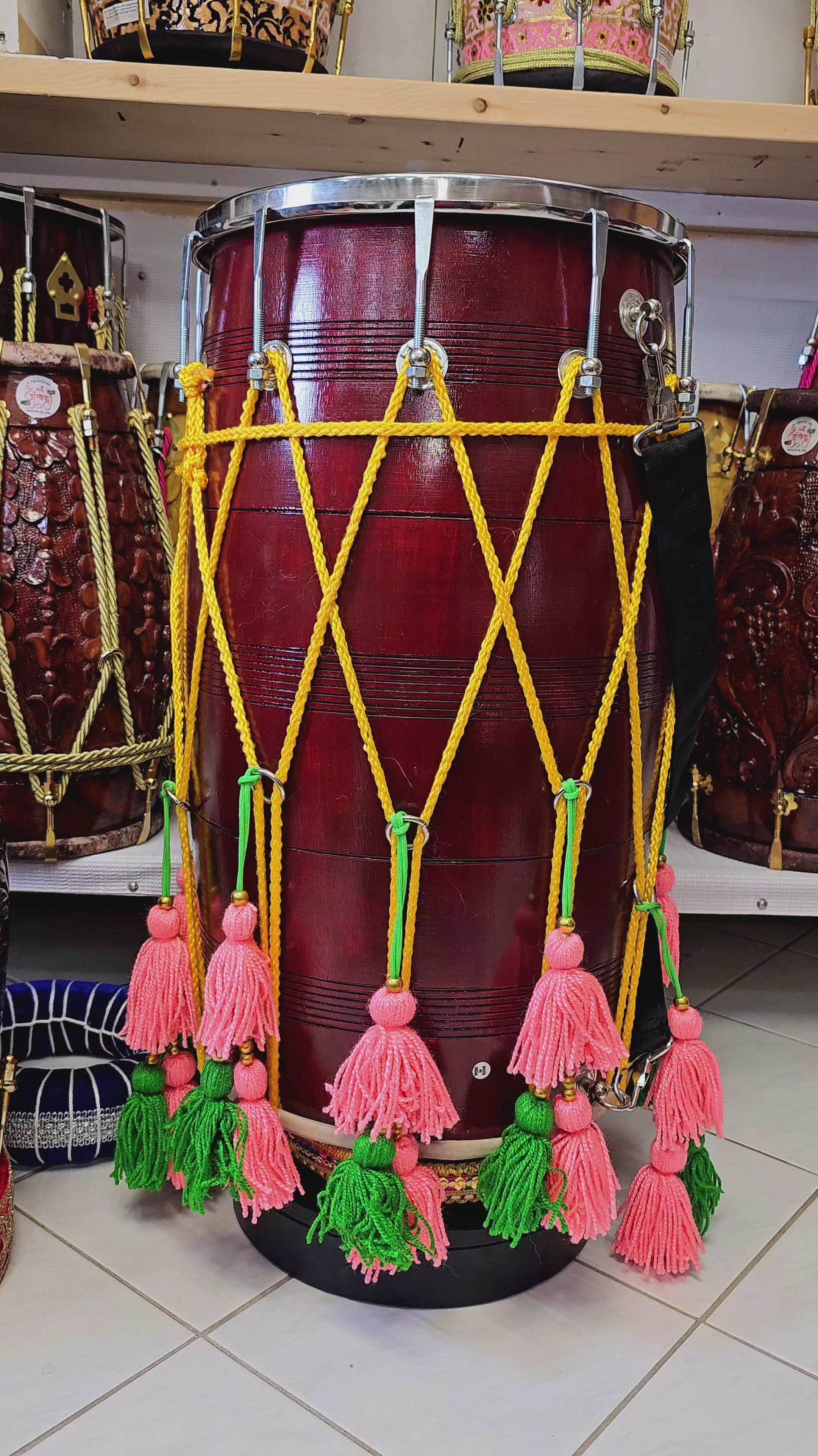 The Burgundy Fiesta Melody Dhol - A Professional Mango Wood Dhol with Yellow Ropes, Chrome Bolts, and Pink and Green Tassels!